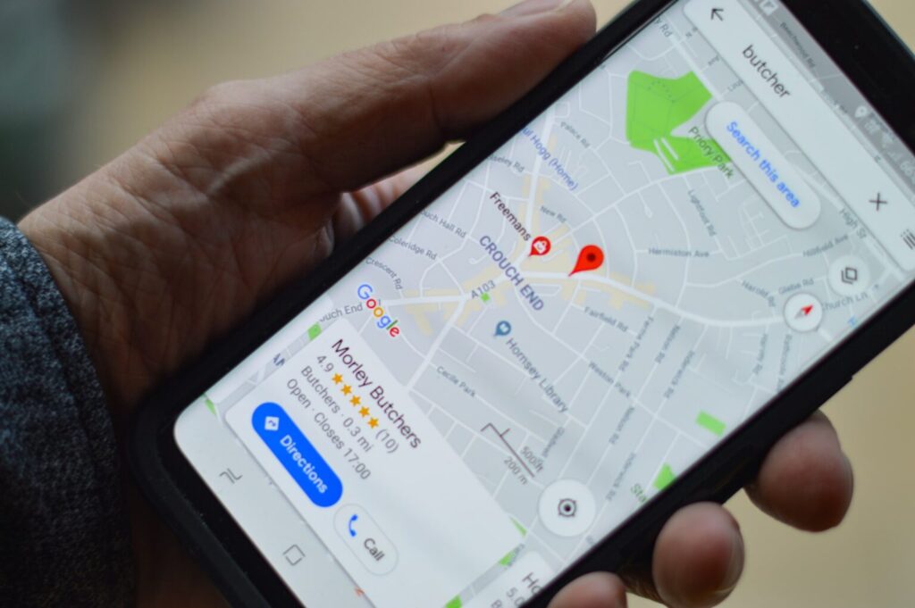 Mão segurando um mobile com a localização de uma empresa no maps. Com o Google Meu Negócio, a sua empresa ganha mais visibilidade na web.