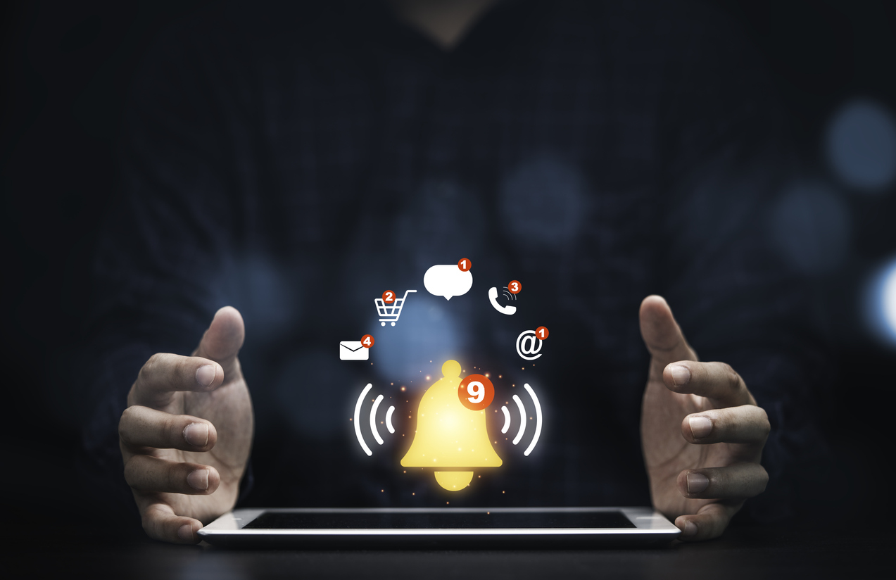 Um homem está com as mãos ao redor de um tablet apoiado em uma mesa, em cima do tablet aparecem desenhados alguns ícones de redes sociais. Use as redes sociais para aumentar suas vendas.